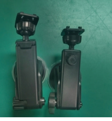 Two black suction cup mount devices on a green surface